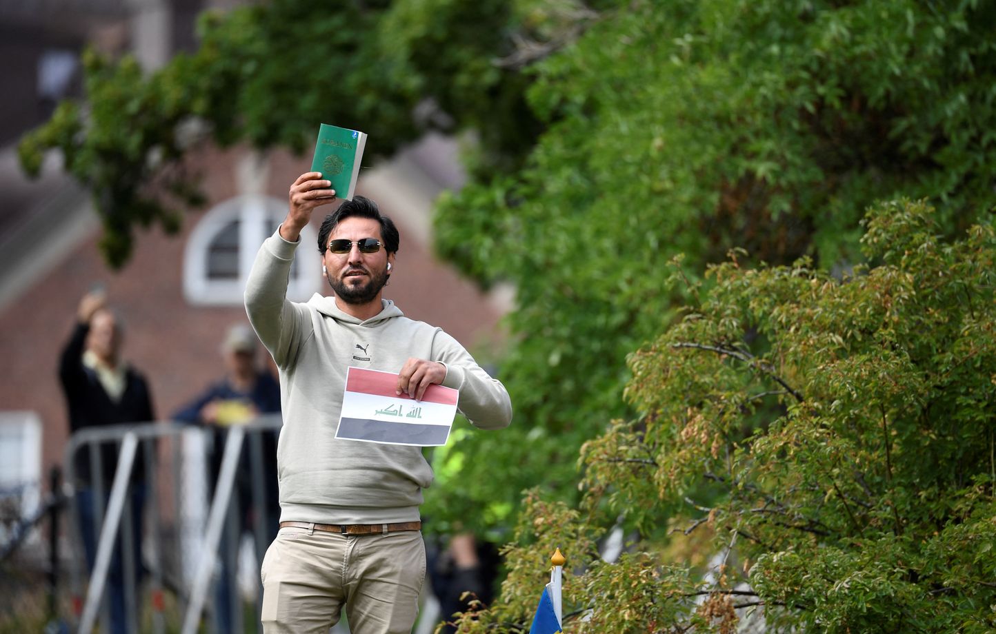 1444x920 protestor salwan momika holds up the muslim holy book and a sheet of paper showing the flag of iraq during a protest outside the iraqi embassy in stockholm sweden on july 20 2023 iraq wa